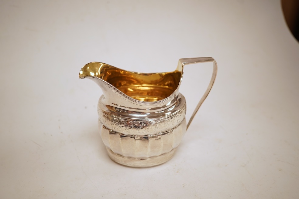 A George III engraved silver helmet shaped cream jug, with fluted body, Soloman Hougham?, London, 1800, height 97mm, 4.5oz (repair).